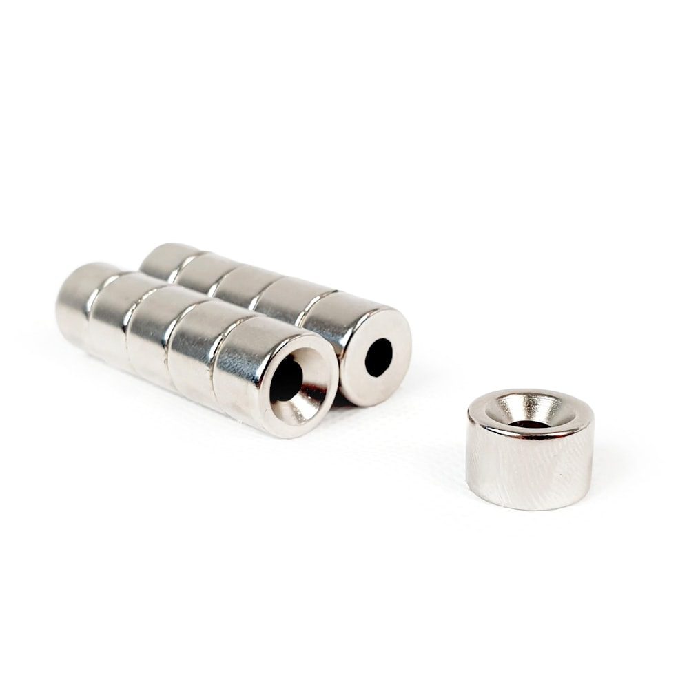 Round Circular Disc Neodymium magnet with countersunk hole for screwing and with dimensions 15mm x 10mm x (6mm Hole), grade N42 , featuring a nickel-copper-nickel coating and an 3.92KG pull force, commonly used in DIY, crafts, furniture design, fixings, kitchen design, lock mechanisms and science experiments.
