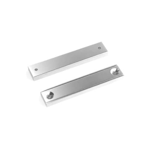 Rectangular block channel magnets with countersunk hole for screwing and with dimensions 60mm x 13.5mm x 5mm (Two 3.3mm c/s holes), grade N35 , featuring a nickel-copper-nickel coating and an 30KG pull force, commonly used for securing into a flat service and used as magnetic door latches or holding display items and signs into place.